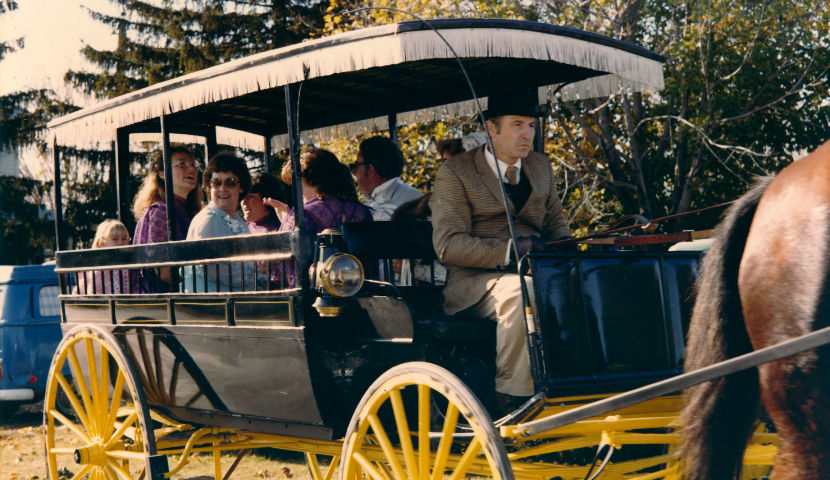 People riding in a historic horse-drawn carriage
